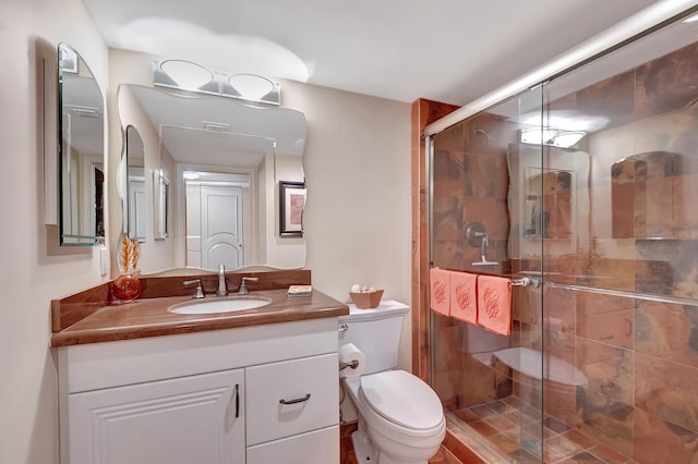 bathroom with a shower with shower door, toilet, and vanity