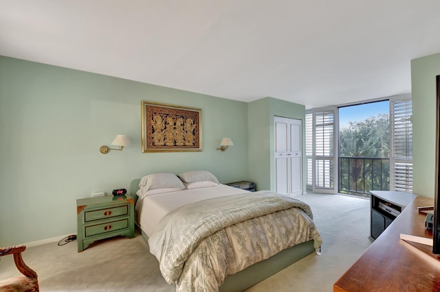 carpeted bedroom with a closet, access to outside, and floor to ceiling windows