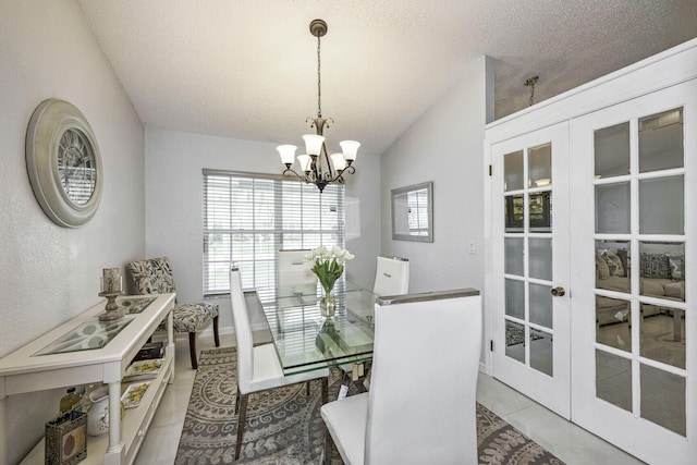 dining space featuring a textured ceiling, french doors, an inviting chandelier, vaulted ceiling, and light tile patterned flooring