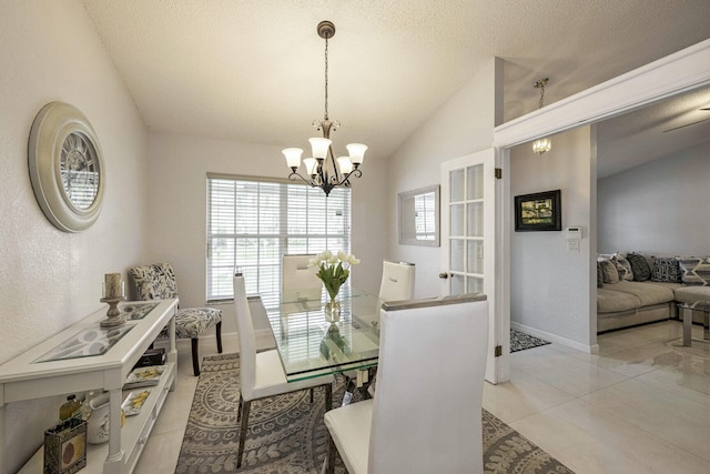 tiled dining area featuring a chandelier, a textured ceiling, and lofted ceiling