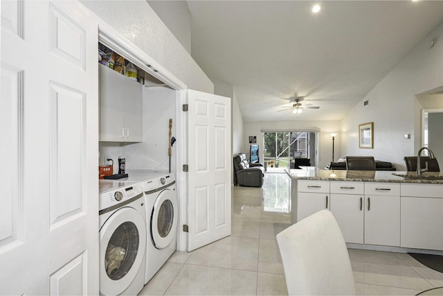 clothes washing area featuring ceiling fan, sink, light tile patterned floors, washer and dryer, and a textured ceiling