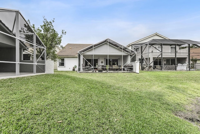 rear view of property with a lanai and a yard