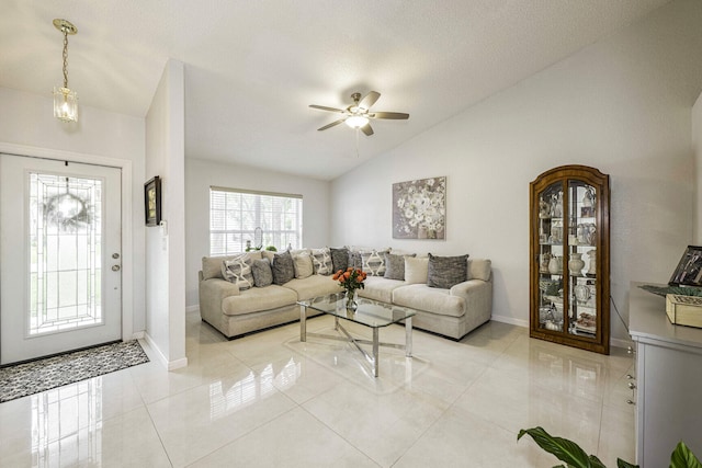 living room with ceiling fan, a textured ceiling, light tile patterned floors, and vaulted ceiling