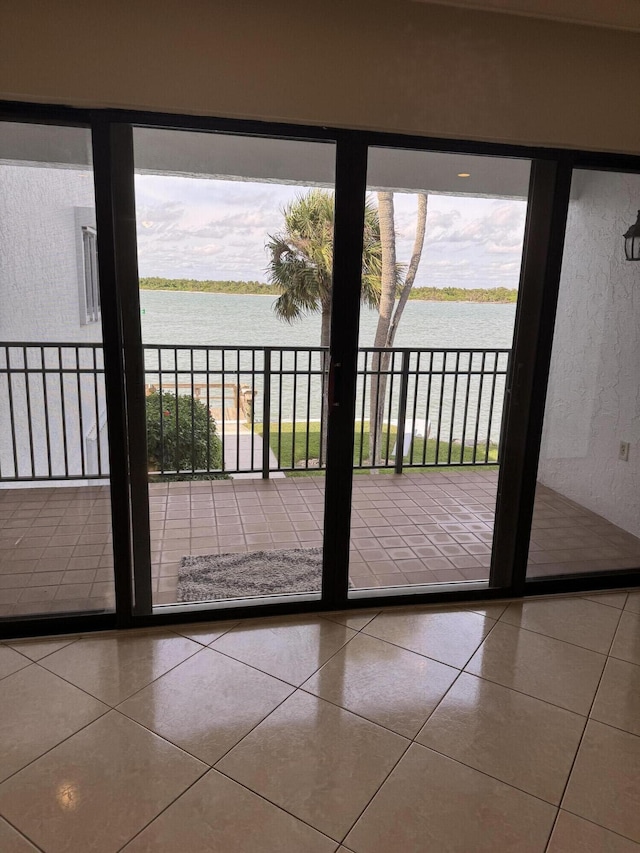 entryway with a water view and tile patterned flooring