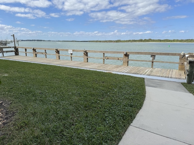 view of dock featuring a water view and a lawn