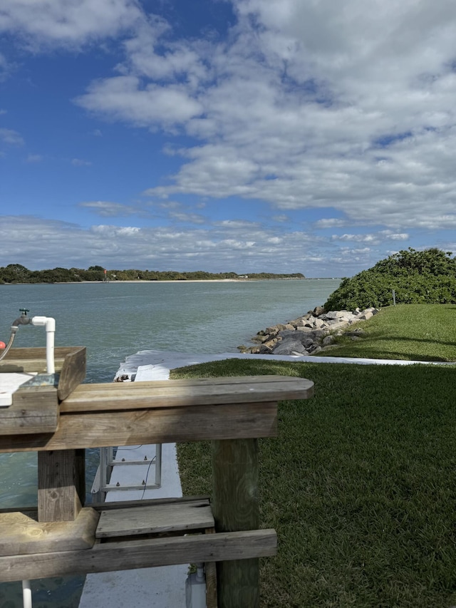 surrounding community featuring a lawn and a water view