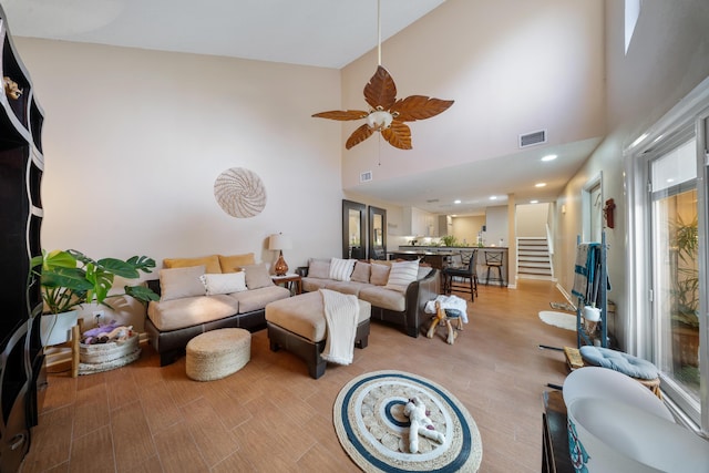 living room featuring high vaulted ceiling, light hardwood / wood-style flooring, and ceiling fan