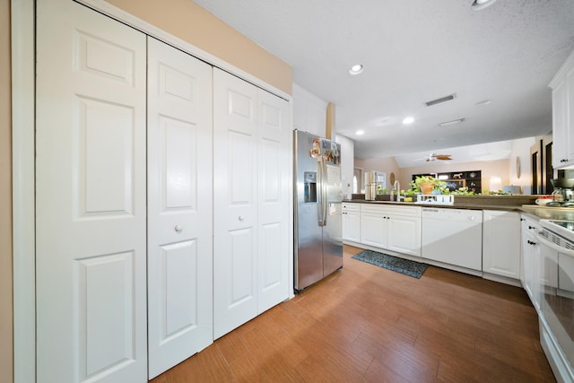 kitchen with light hardwood / wood-style floors, kitchen peninsula, ceiling fan, white appliances, and white cabinets