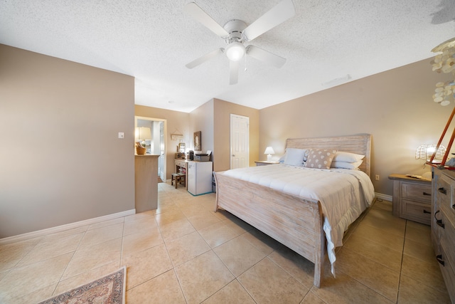 tiled bedroom with a textured ceiling, ceiling fan, and a closet