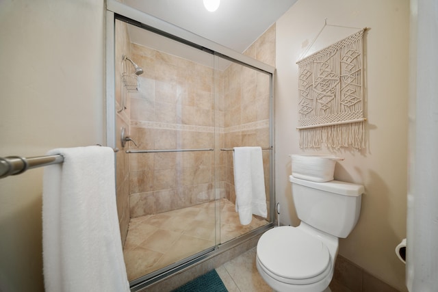 bathroom with a shower with shower door and toilet