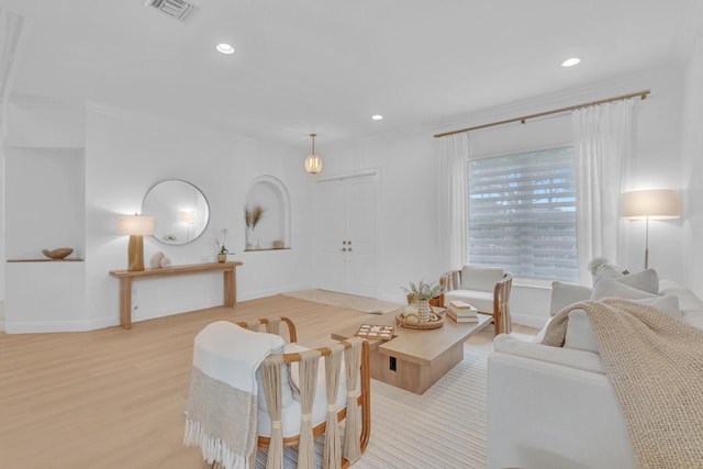 living room featuring ornamental molding and light hardwood / wood-style floors