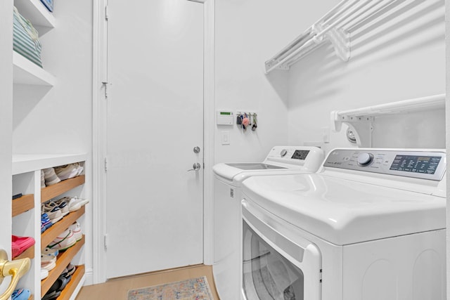 washroom featuring light hardwood / wood-style flooring and washing machine and clothes dryer