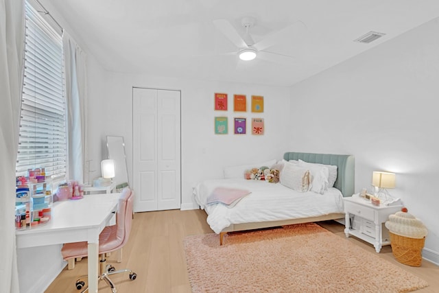 bedroom with ceiling fan, light wood-type flooring, and a closet