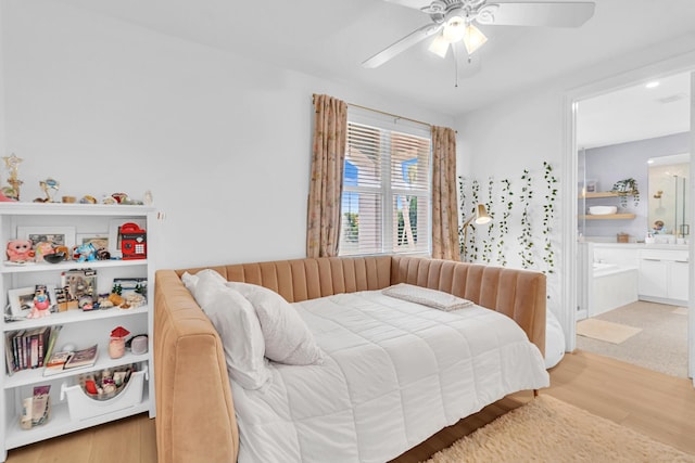 bedroom with ceiling fan, connected bathroom, and light hardwood / wood-style flooring