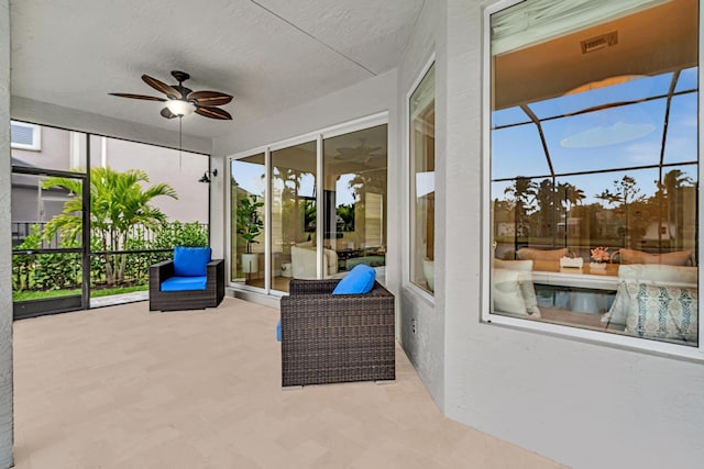 unfurnished sunroom featuring ceiling fan