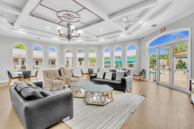 living room with coffered ceiling, a towering ceiling, light hardwood / wood-style floors, and french doors