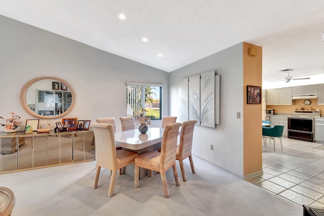 dining space featuring vaulted ceiling and light colored carpet