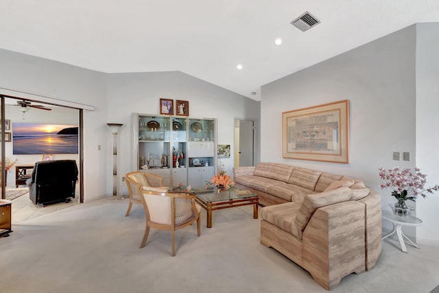 living room with ceiling fan, light colored carpet, and vaulted ceiling