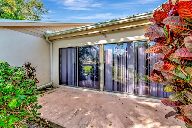 2430 NW 12th St, Delray Beach, FL 33445 - property entrance with stucco siding and a patio