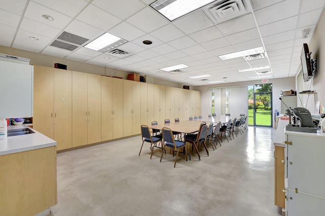 dining space with sink and a drop ceiling