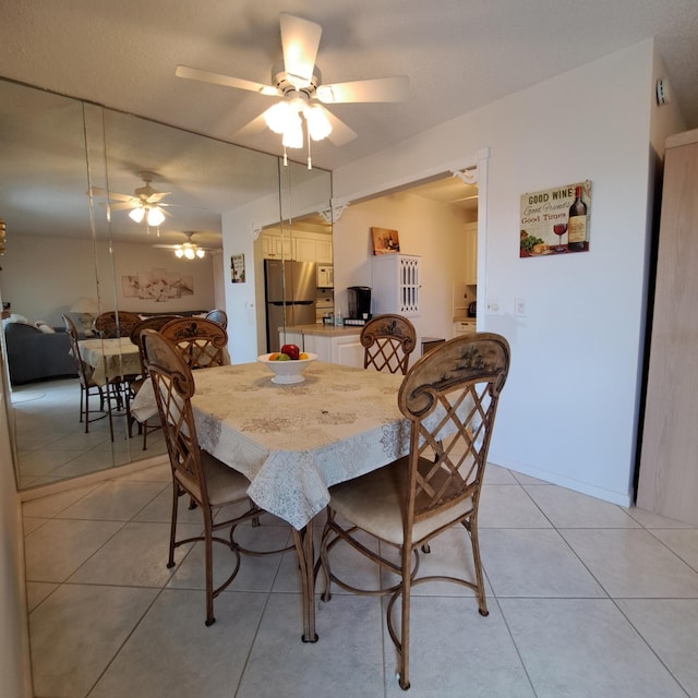 tiled dining space with ceiling fan