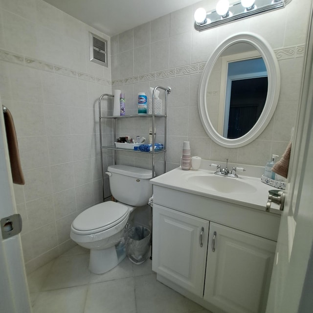 bathroom featuring tile walls, toilet, vanity, and tile patterned flooring