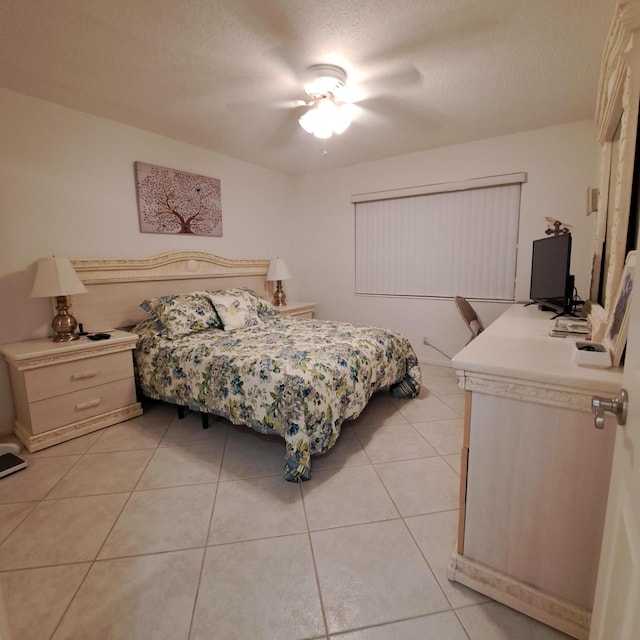 bedroom featuring a textured ceiling, ceiling fan, and light tile patterned floors