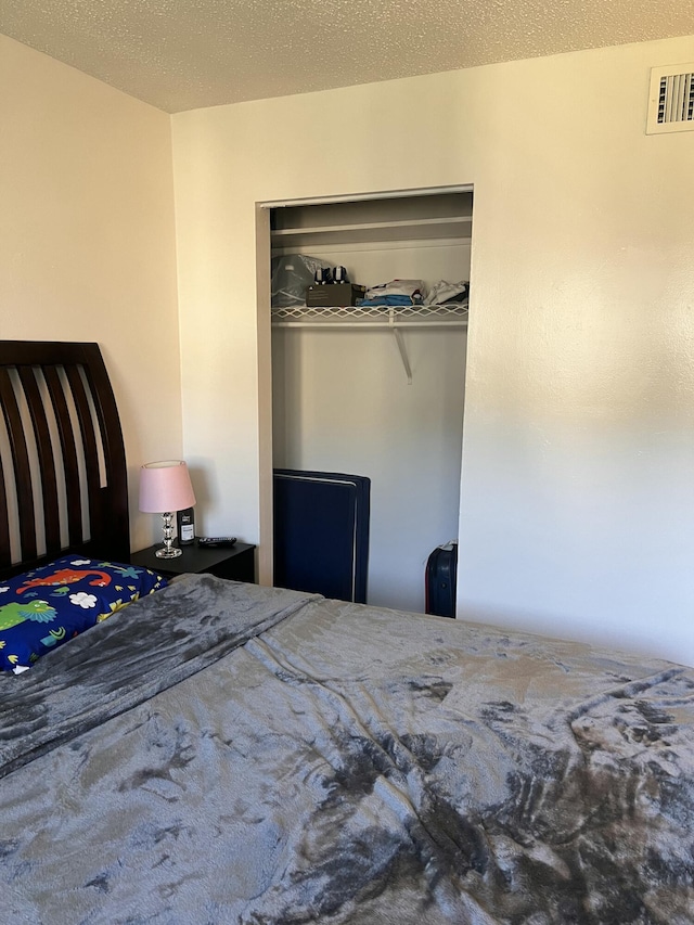 unfurnished bedroom featuring a textured ceiling and a closet