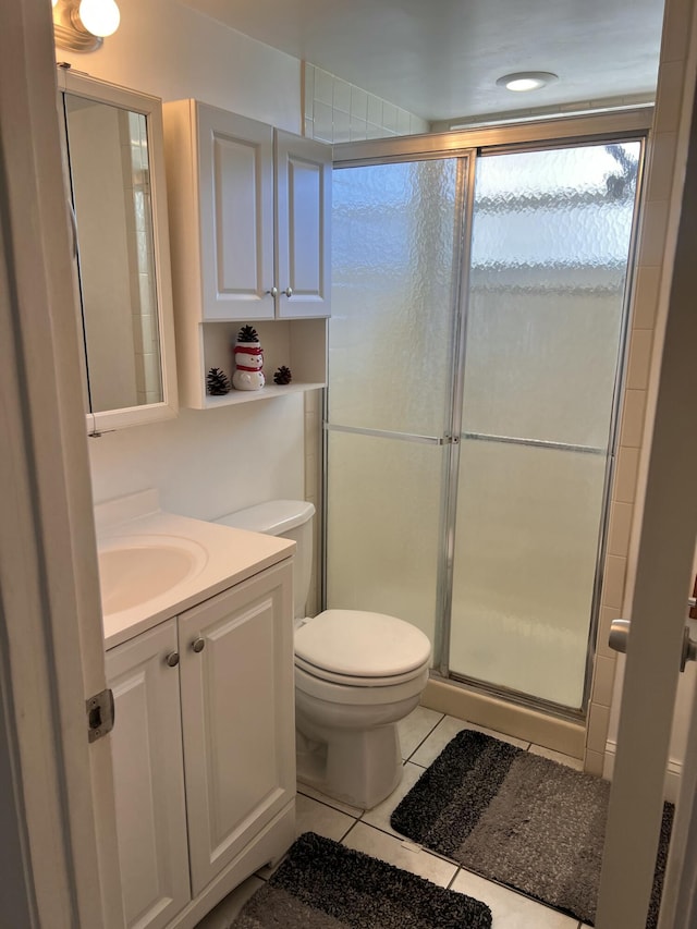 bathroom featuring an enclosed shower, vanity, tile patterned flooring, and toilet