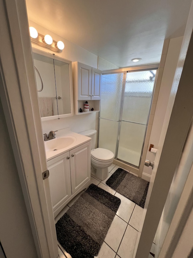 bathroom with an enclosed shower, vanity, tile patterned floors, and toilet