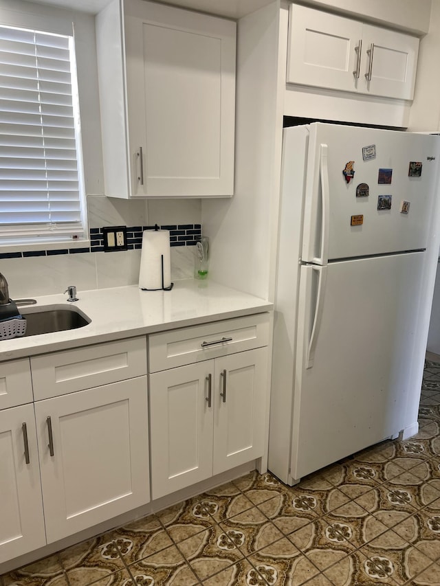 kitchen featuring white refrigerator and white cabinets