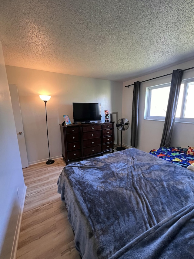 bedroom featuring a textured ceiling and light hardwood / wood-style floors