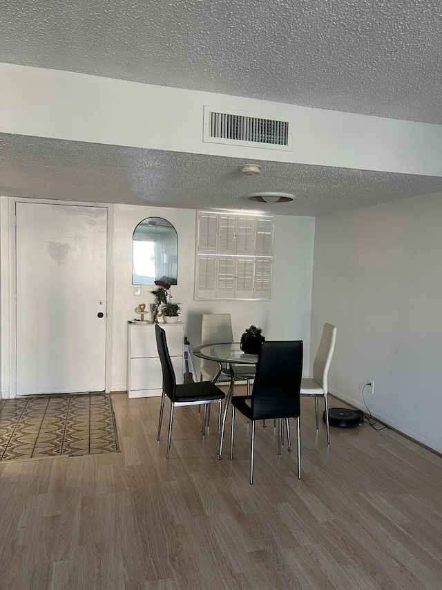 dining room featuring a textured ceiling and hardwood / wood-style floors