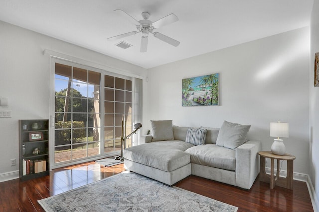 living room with dark hardwood / wood-style flooring and ceiling fan