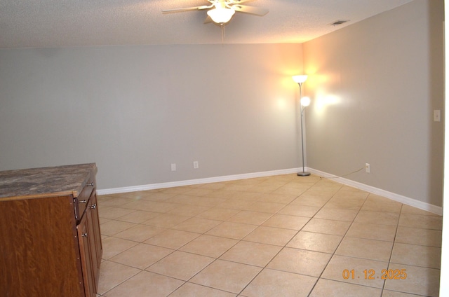 tiled spare room featuring ceiling fan and a textured ceiling