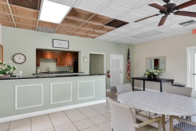 kitchen featuring ceiling fan, sink, and light tile patterned floors