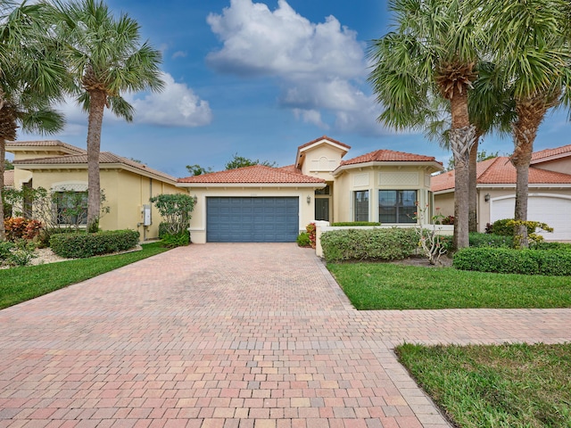 mediterranean / spanish house with a front lawn and a garage