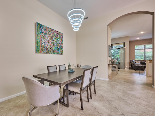 tiled dining room featuring a chandelier