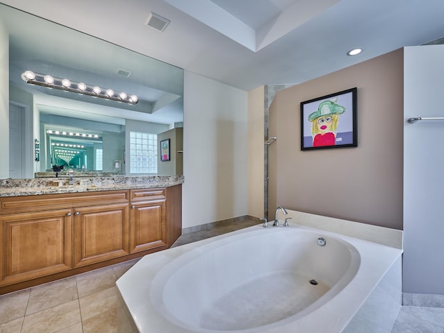 bathroom featuring tile patterned floors, tiled tub, and vanity