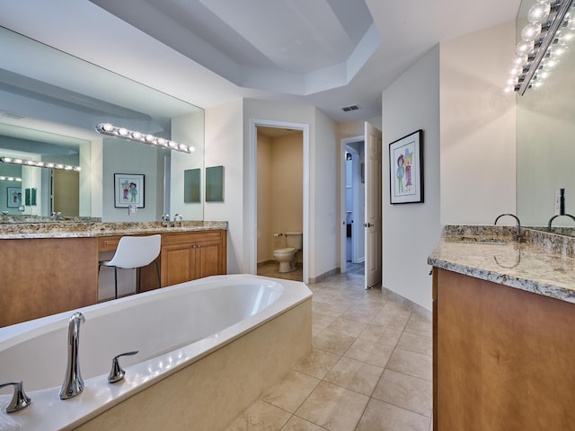 bathroom with toilet, vanity, a bath, and tile patterned flooring