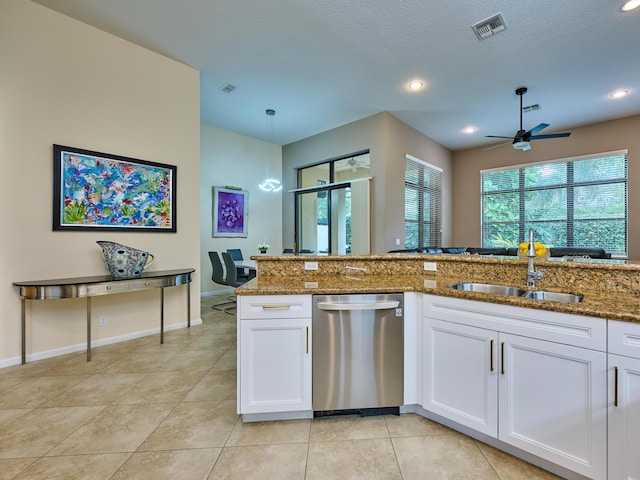 kitchen featuring stainless steel dishwasher, white cabinets, dark stone counters, and sink