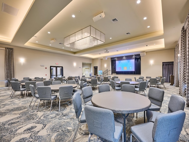 carpeted dining space featuring a raised ceiling