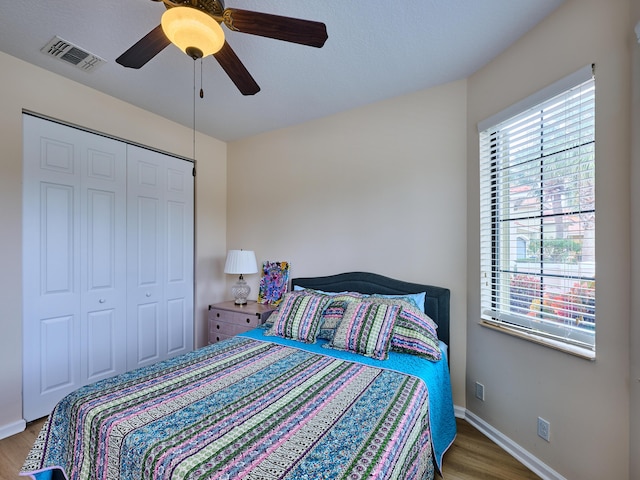 bedroom with ceiling fan, a closet, and hardwood / wood-style flooring