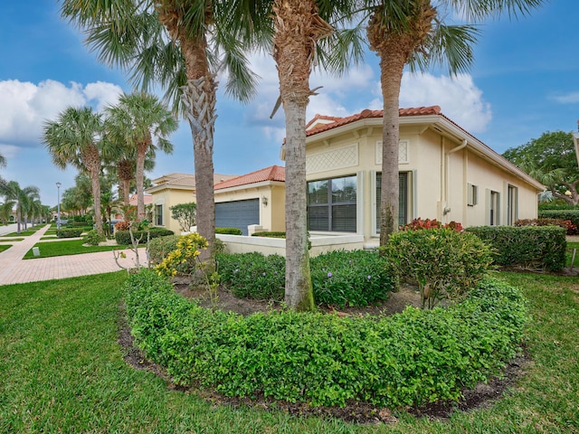 view of home's exterior featuring a garage and a lawn