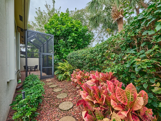 view of yard with glass enclosure and a patio