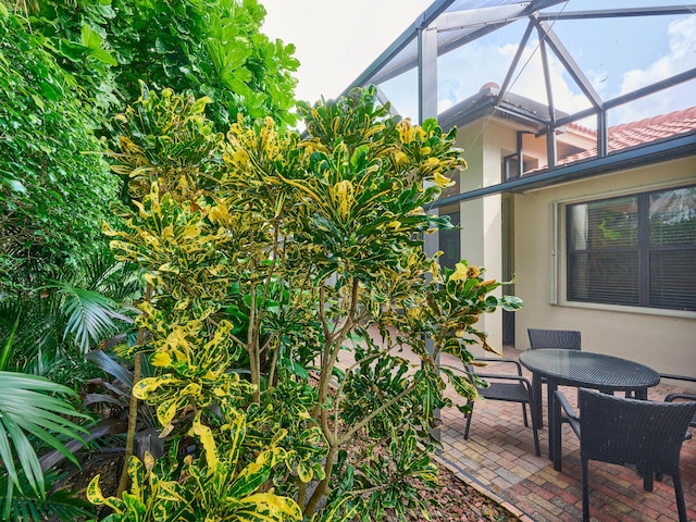 view of patio featuring glass enclosure