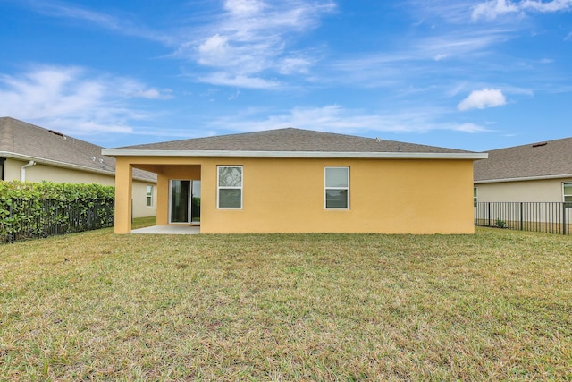 rear view of house with a lawn and a patio