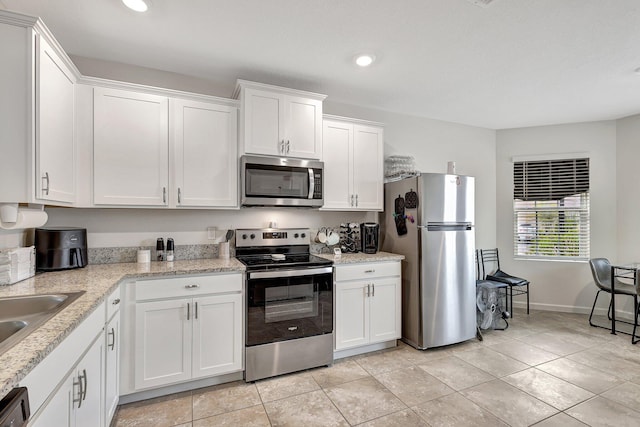 kitchen with white cabinetry, appliances with stainless steel finishes, and light tile patterned floors