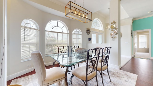 dining room with dark hardwood / wood-style floors, ornamental molding, and a notable chandelier