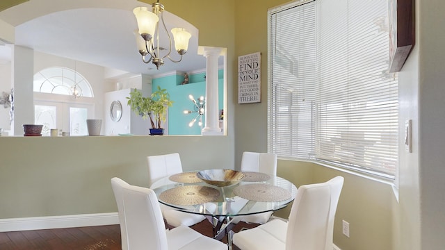 dining area featuring french doors, ornate columns, a chandelier, and hardwood / wood-style floors